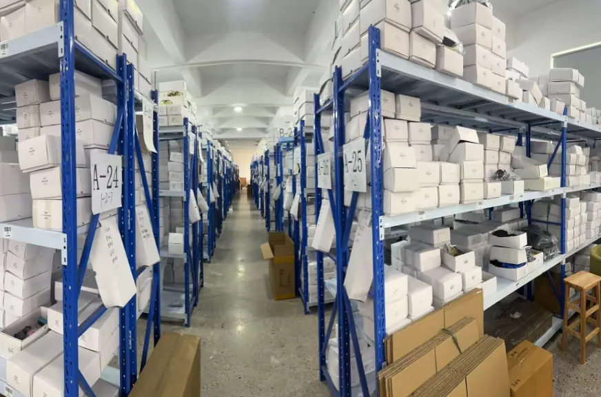 Labeled aisles of boxed eyewear inventory in the KUANGTU warehouse