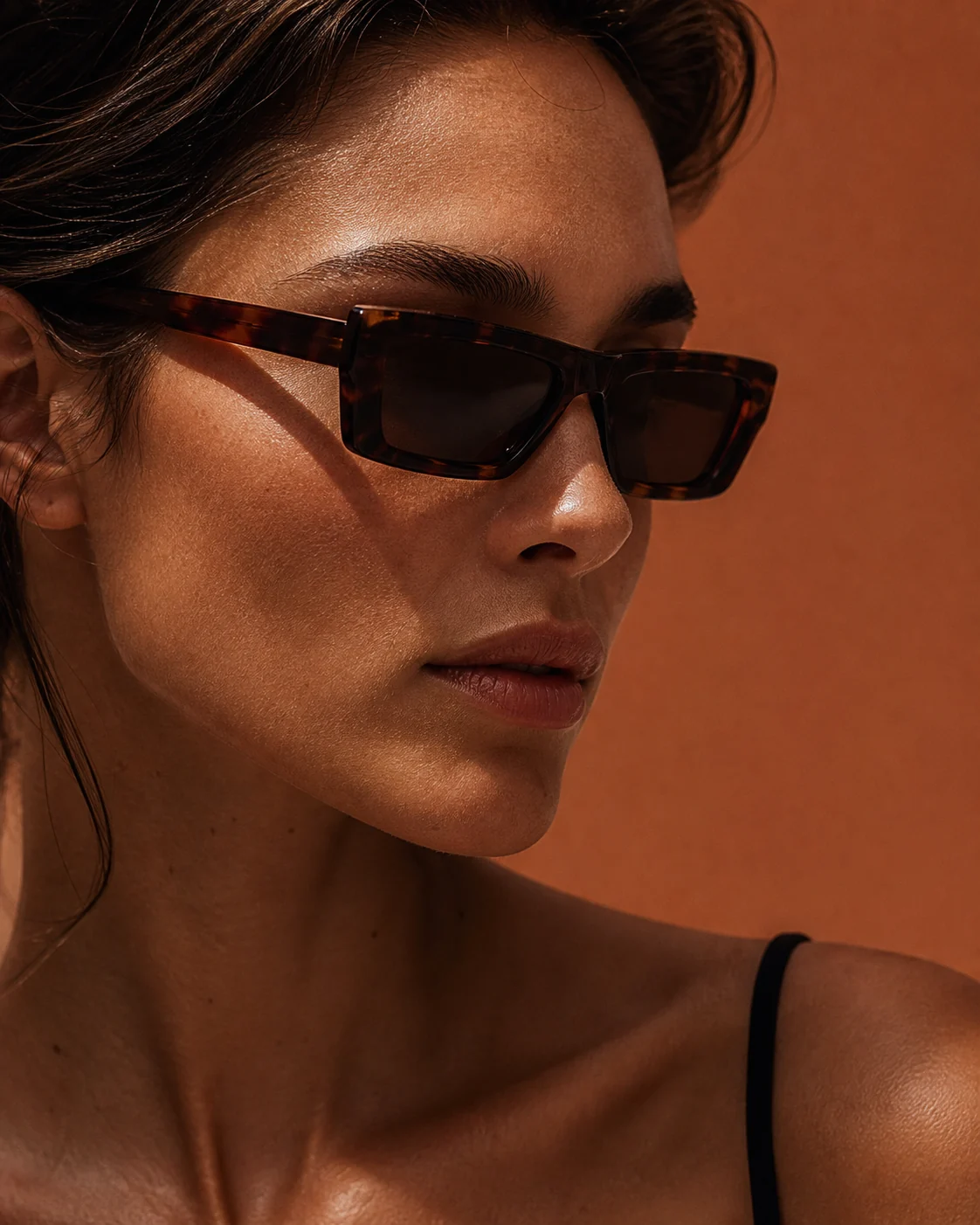 Close editorial portrait wearing angular dark tortoiseshell sunglasses